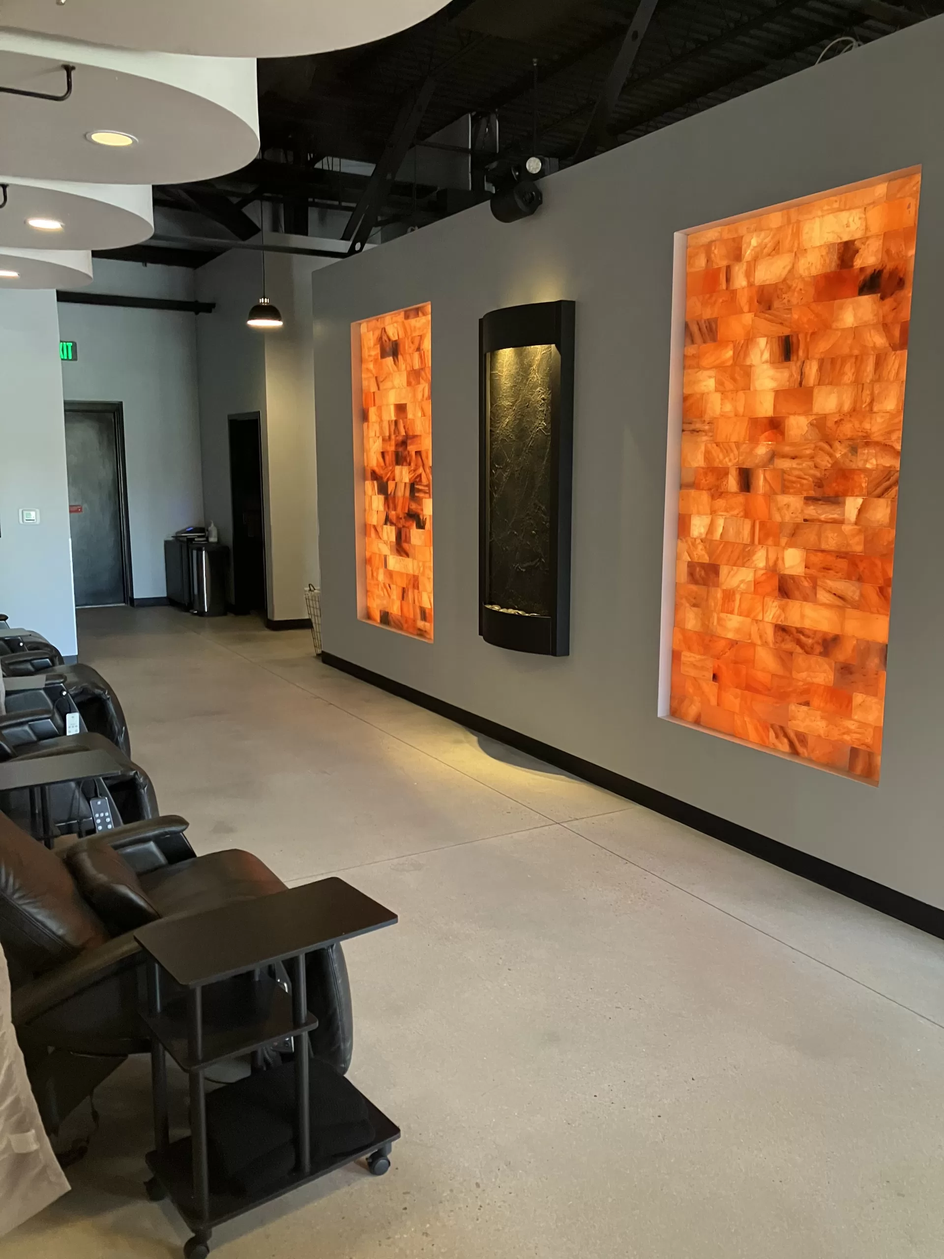 A room with chairs, a wall of orange bricks, and blood testing services.