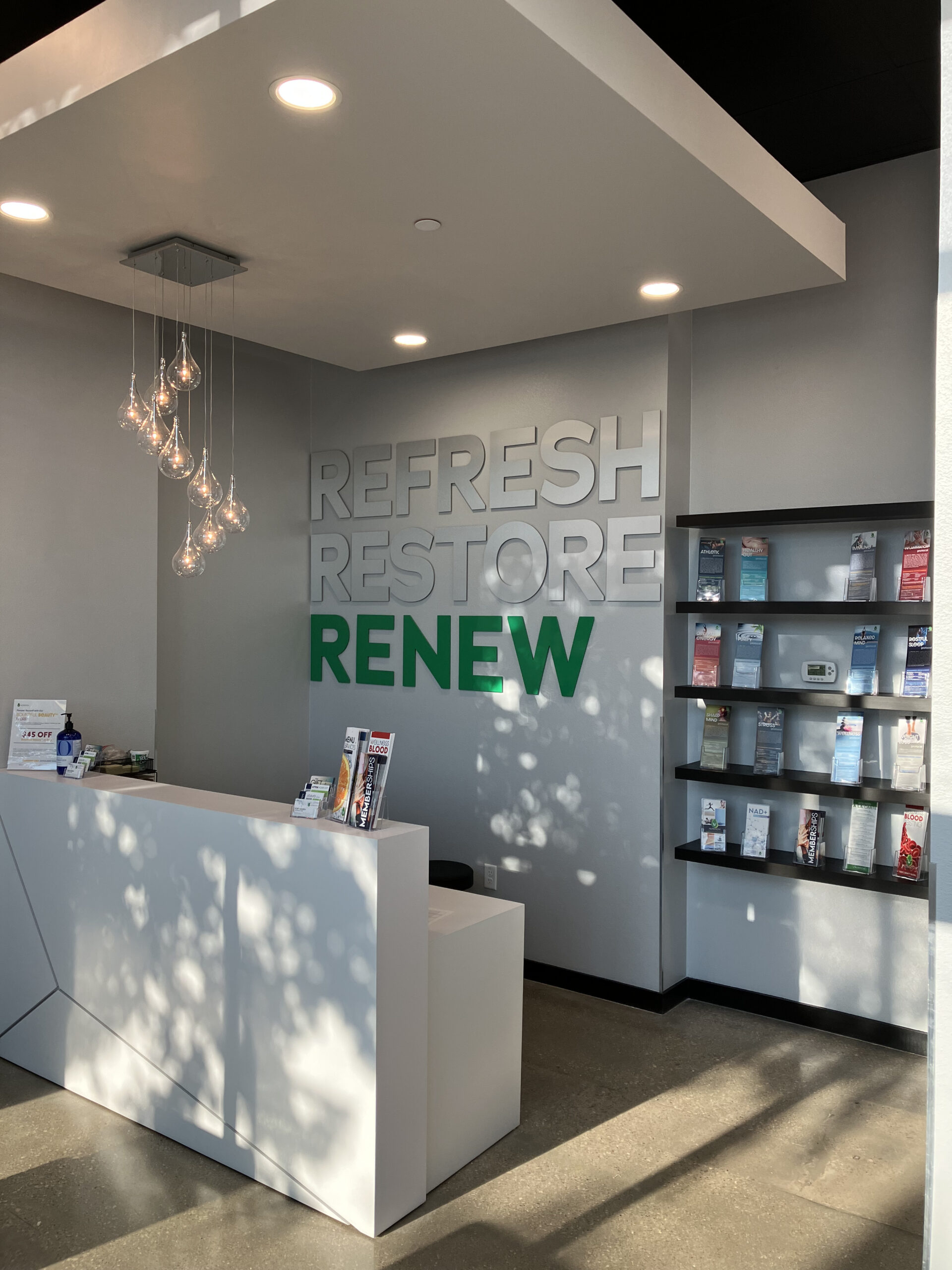 A reception desk in a store offering drip hydration, vitamin injection, and IV therapy services.