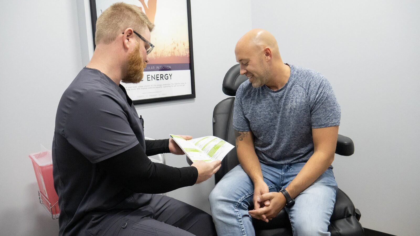 Two men sitting in a chair, discussing nutritional IV therapy and drip hydration with each other.